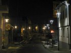 Die Laternen links strahlen viel Licht sinnlos in den Nachthimmel, in Wohnungen und auf Hausfassaden, die Leuchten rechts strahlen viel Licht ungenutzt am Reflektorspiegel vorbei nach oben